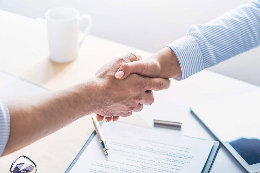 Händeschütteln zwischen zwei Personen bei einem Geschäftstreffen.